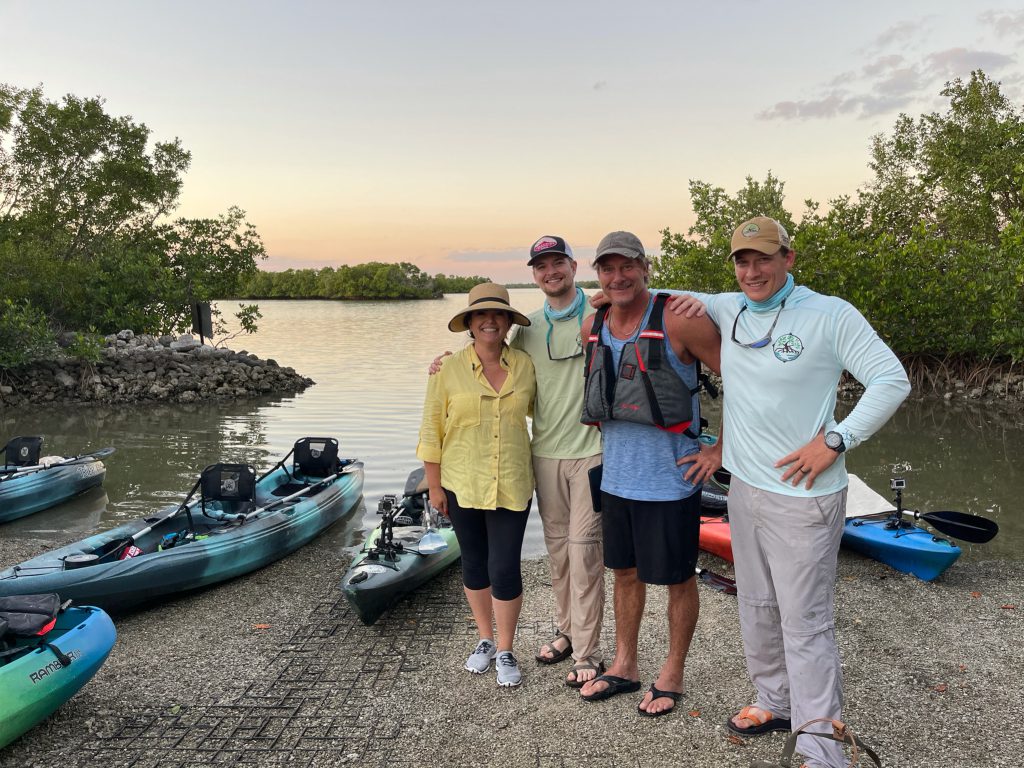 Ty Pennington et al. standing next to a lake